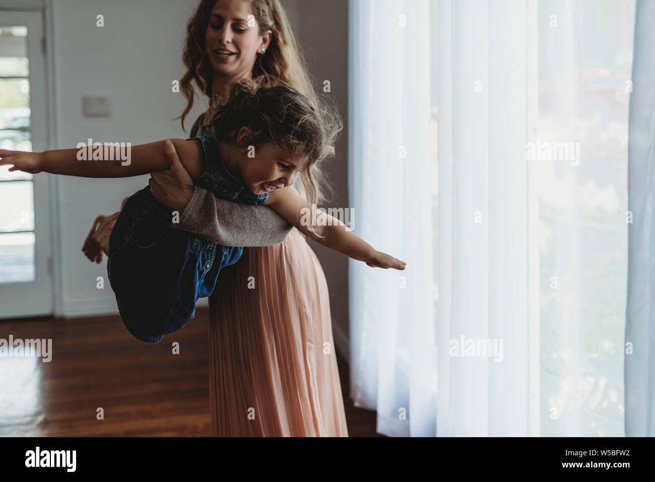 Mère et fille à l'avion en lumière naturelle studio Banque D'Images