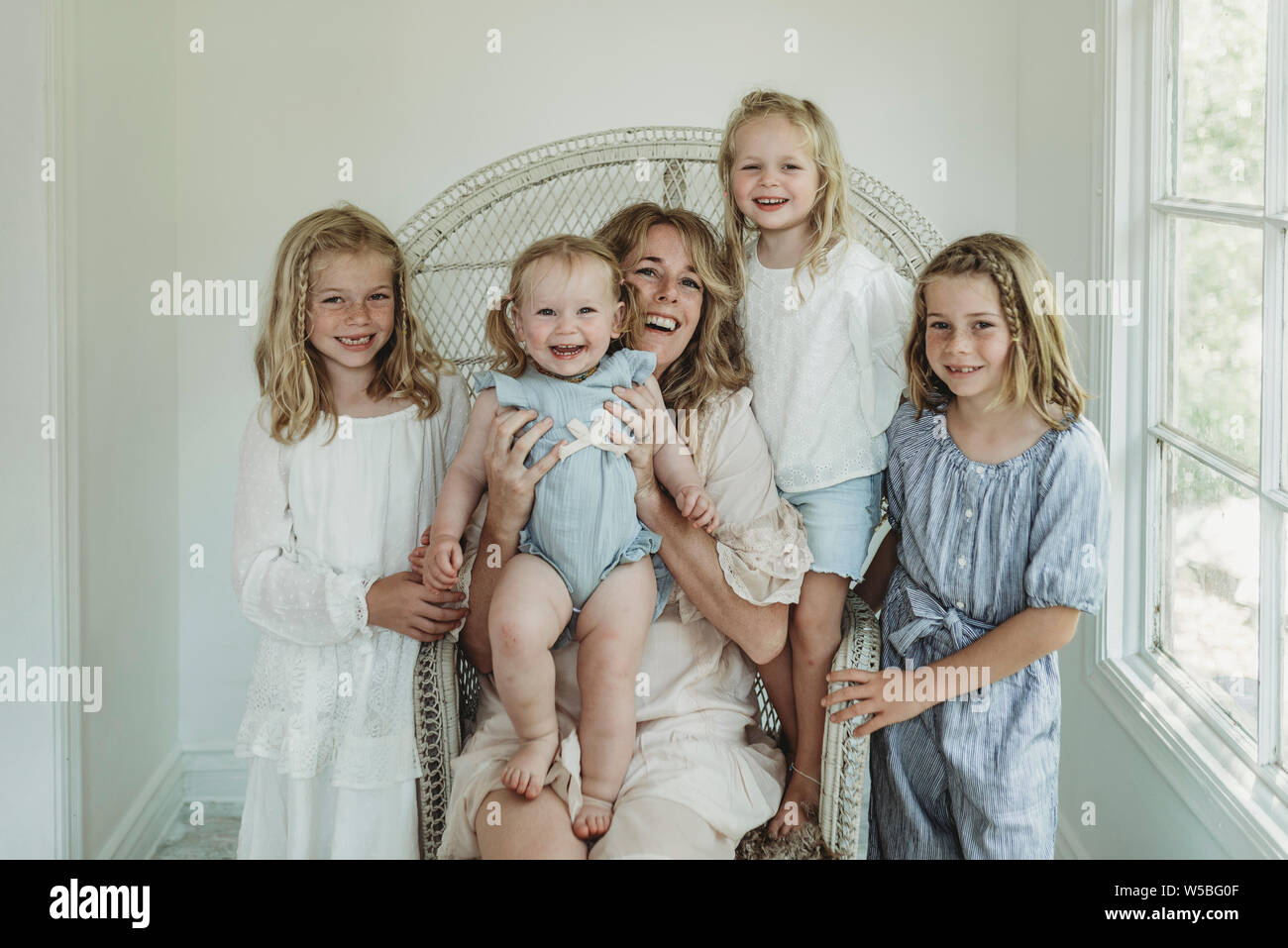 Mère assise dans un fauteuil avec bohème smiling filles Banque D'Images