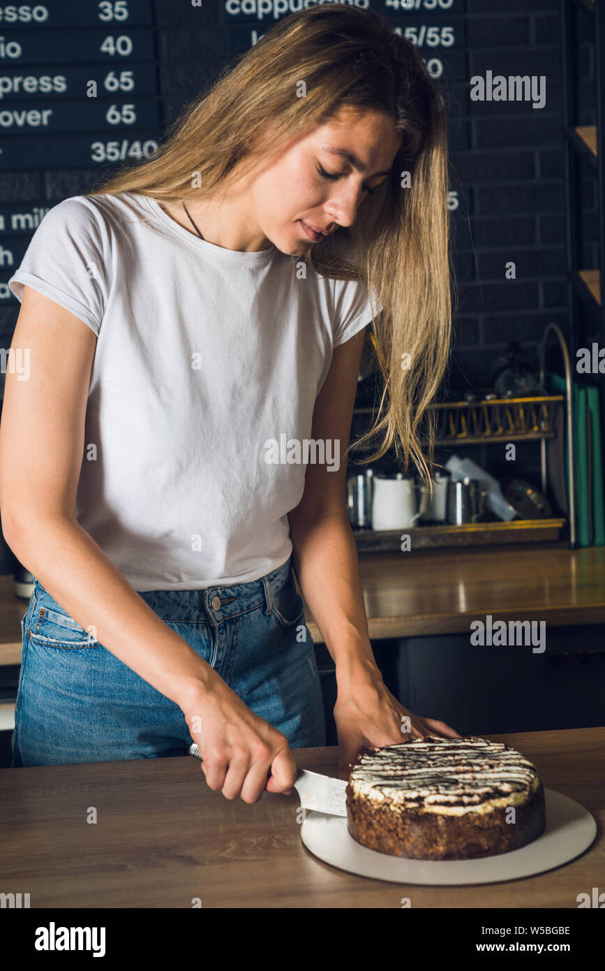 Jeune Femme En Blanc T Shirt Couper Un Gateau Au Chocolat Dans Le Cafe Photo Stock Alamy