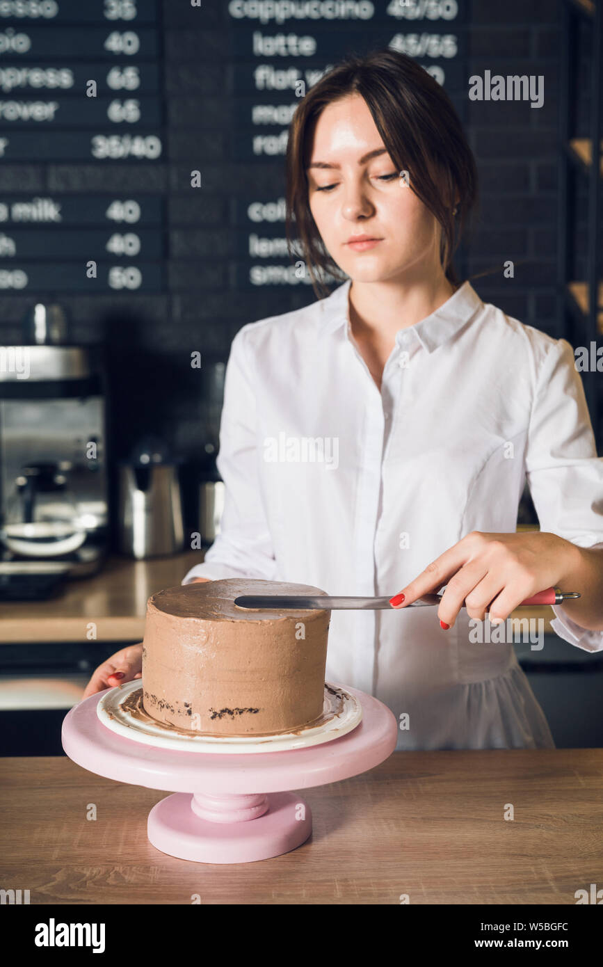 Woman's hands en chemise blanche crème sur un top de chocolat ca Banque D'Images