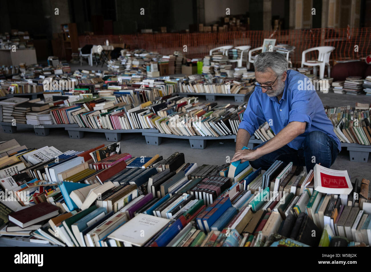 Athènes, Grèce. 26 juillet, 2019. Koursoumis Leonidas, un ancien sans-abri qui a lancé la librairie d'occasion, organise des livres dans la librairie dans le centre d'Athènes, Grèce, le 26 juillet 2019. Un ancien sans-abri, une initiative, l'intervention de centaines de personnes, un entrepôt dans le centre d'Athènes. Tous les combinés des ingrédients ', est devenue la première librairie de livres d'occasion dirigé par sans-abri. (Photo par Nathalie Partsalis/Xinhua) POUR ALLER AVEC 'caractéristique : Première librairie d'occasion dirigé par sans-abri en Grèce donne espoir aux personnes dans le besoin en matière de crédit : Xinhua/Alamy Live News Banque D'Images