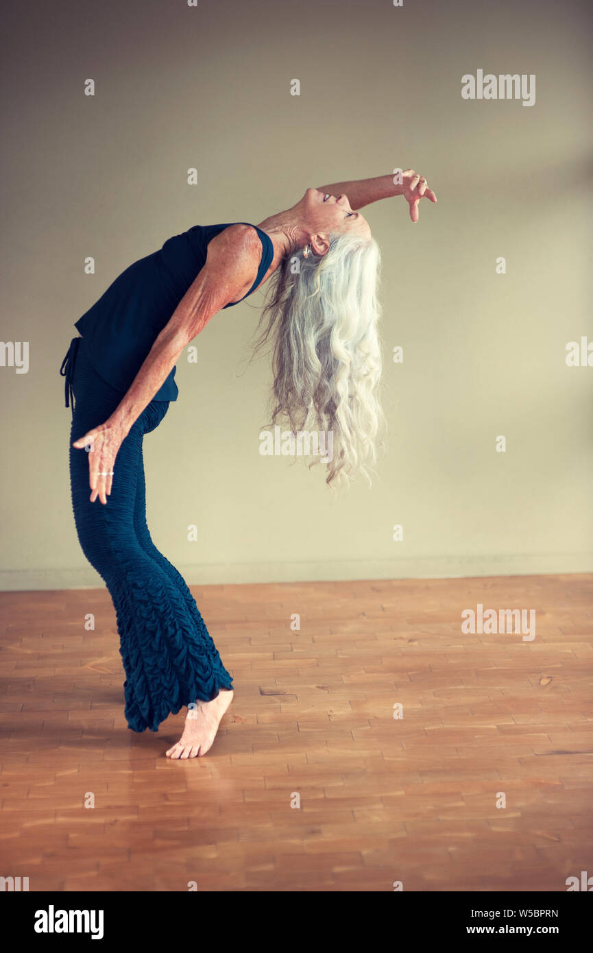 Free spirited monter aux cheveux longs femme mature s'exprimer à travers la danse extatique. Banque D'Images