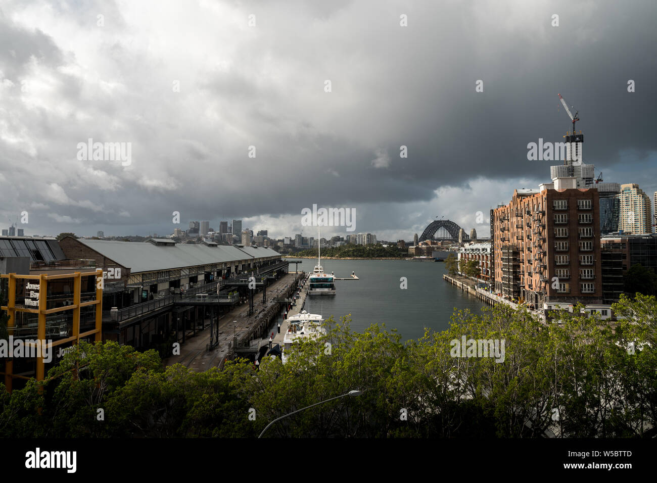 Pyrmont, Nouvelle Galles du Sud - Juin 24th, 2019 : les nuages menaçants pendre Jones Bay Wharf avec North Sydney visible dans l'arrière-plan. Banque D'Images