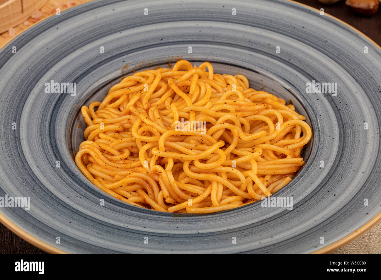 Spaghetti à la sauce bolognaise dans un bol avec les tomates, le romarin et d'épices. Noir sur fond rustique Banque D'Images