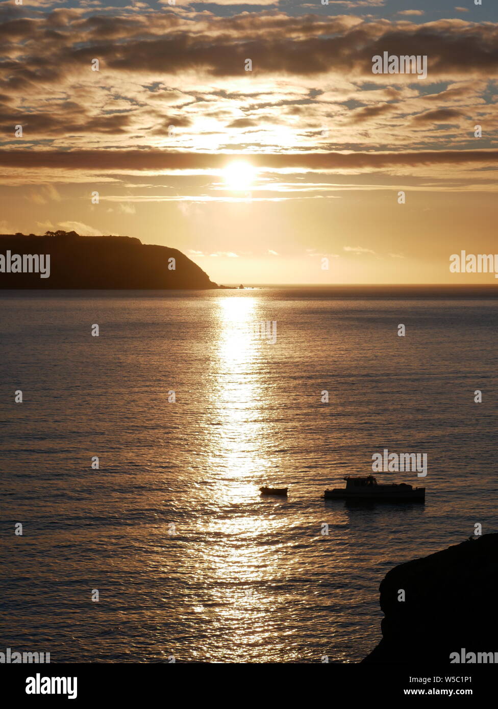 Soleil derrière l'île de Mana, sur un jour d'hiver calme - bateau de pêche qui se profile à l'avant-plan. Photo prise à partir de Titahi Bay, Wellington, Nouvelle Ze Banque D'Images