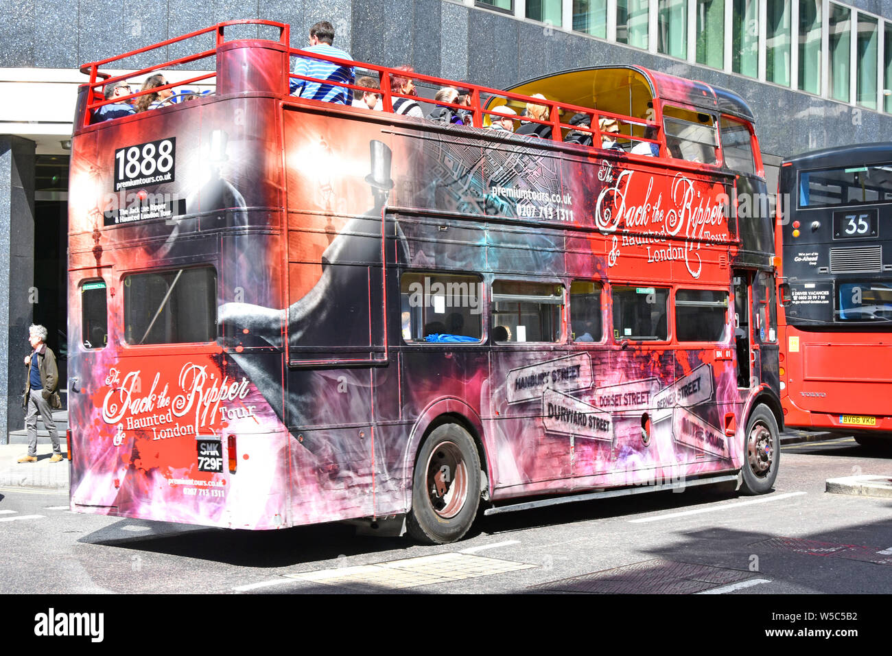 Jack the Ripper historique open top double decker bus visite guidée couverts avec des graphique top deck avec les touristes & guide Angleterre Londres UK Banque D'Images