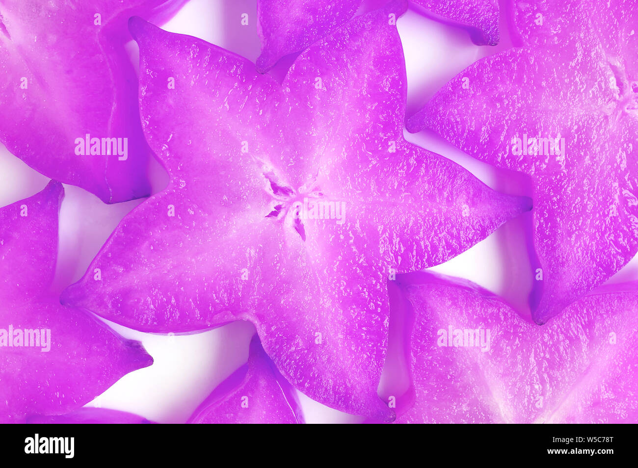 Vue de dessus de Star Fruits frais tranchés dans un style Pop Art surréaliste pour le fond de couleur pourpre Banque D'Images