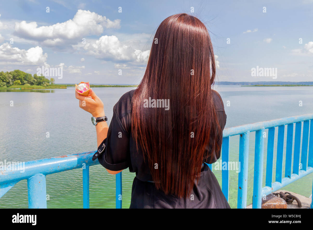 Fille avec de magnifiques cheveux lisses mange la crème glacée Banque D'Images