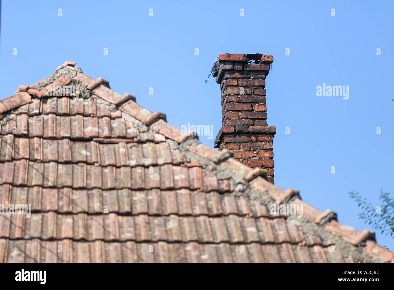 Détails avec l'ancien les tuiles et briques rouges avec la cheminée d'une maison dans un village rural en Roumanie Banque D'Images