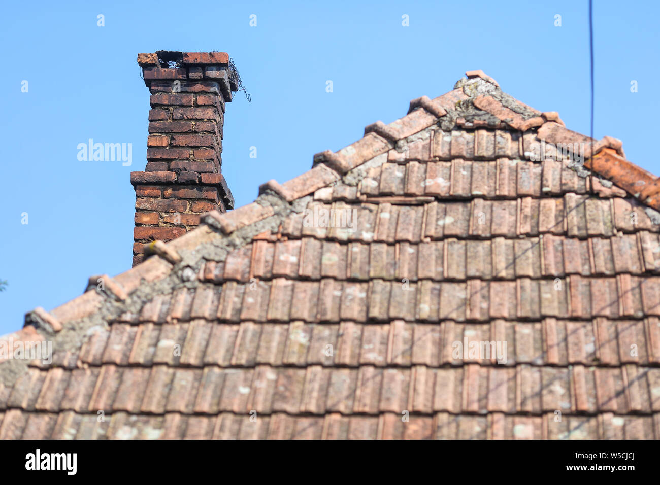 Détails avec l'ancien les tuiles et briques rouges avec la cheminée d'une maison dans un village rural en Roumanie Banque D'Images