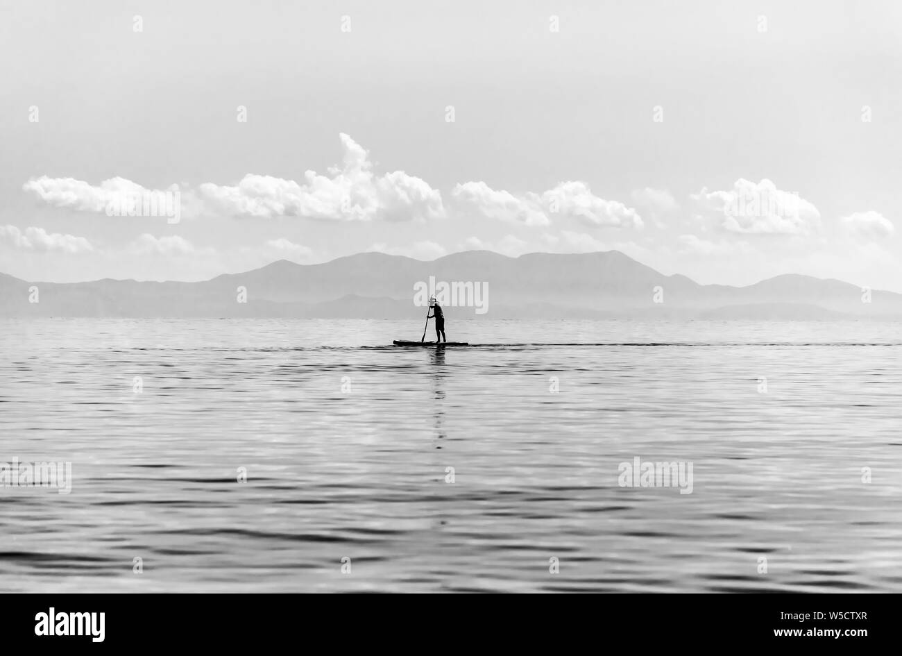 Paddle Boarder à la plage de Stafilos Skopelos, Sporades du Nord, Grèce. Banque D'Images