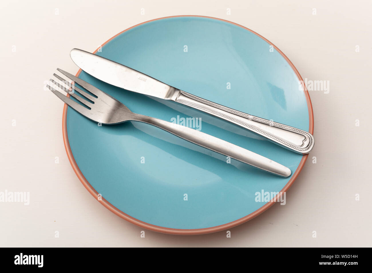 Le couteau et la fourchette sur l'assiette bleue pastel tableau blanc sur Banque D'Images