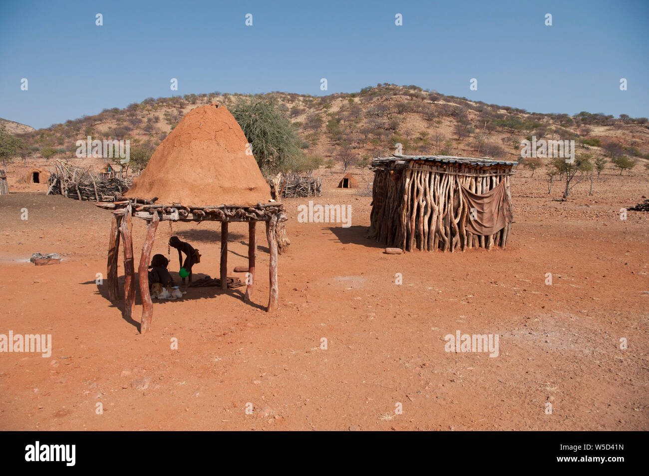 Village de la tribu Himba, Kaokoveld, Namibie, Afrique. Le hangar de droite est utilisé pour le stockage de céréales ou de bétail Banque D'Images