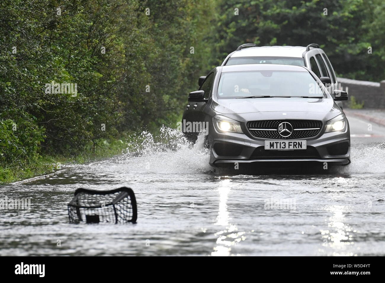Les voitures font leur chemin à travers l'eau stagnante dans Loughborough après de fortes pluies ont diminué dans tout le pays. Banque D'Images