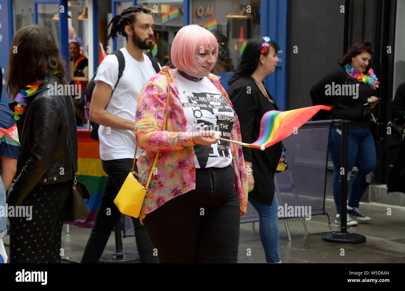 Chubby dame aux cheveux roses, en agitant le drapeau arc-en-ciel Banque D'Images