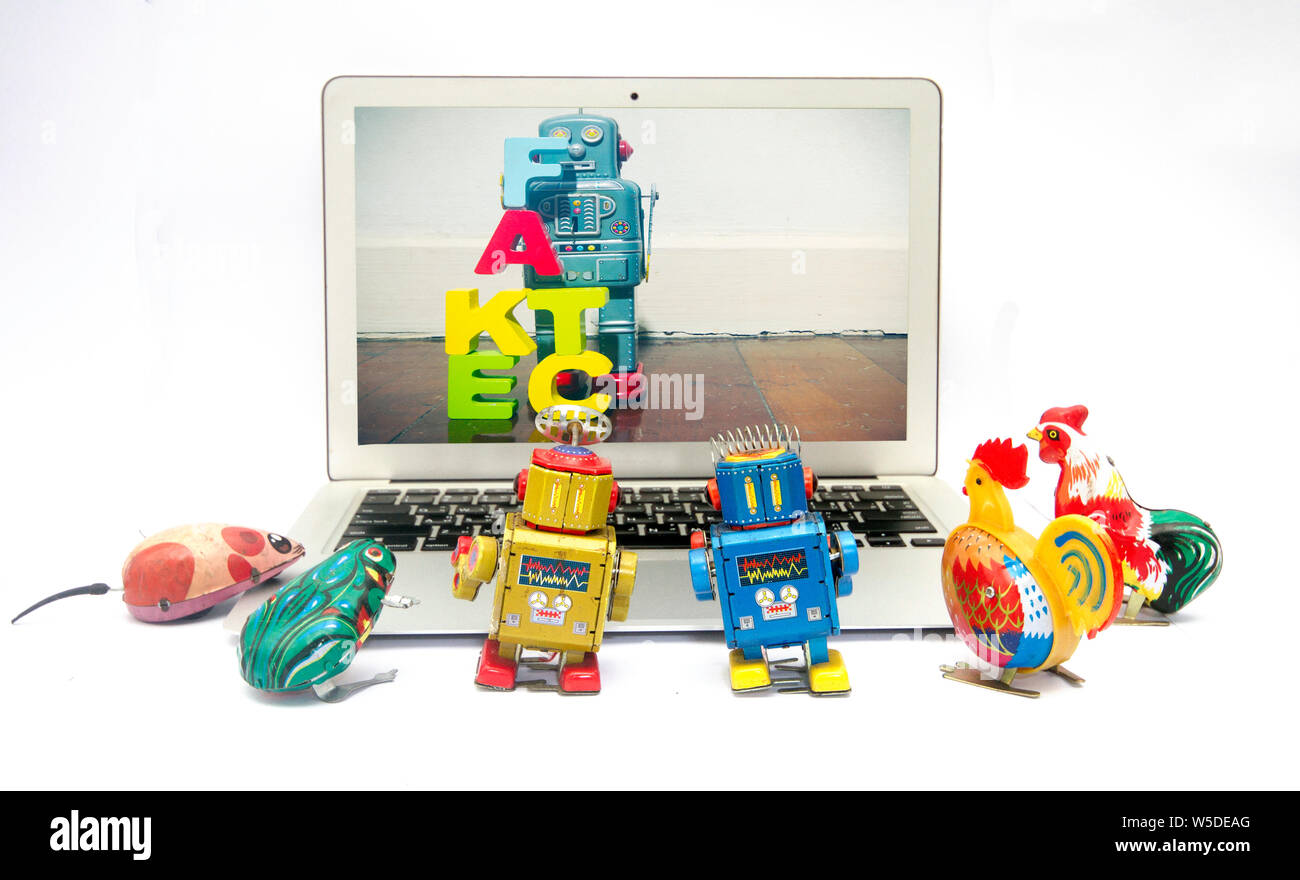 Fake news concept avec la boîte de jouets rétro regarder les nouvelles sur un laptp Banque D'Images