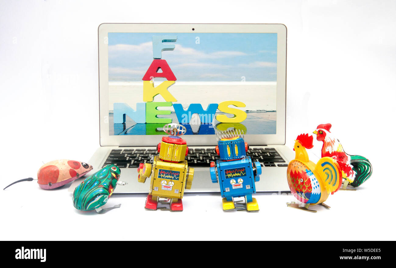 Fake news concept avec la boîte de jouets rétro regarder les nouvelles sur un laptp Banque D'Images