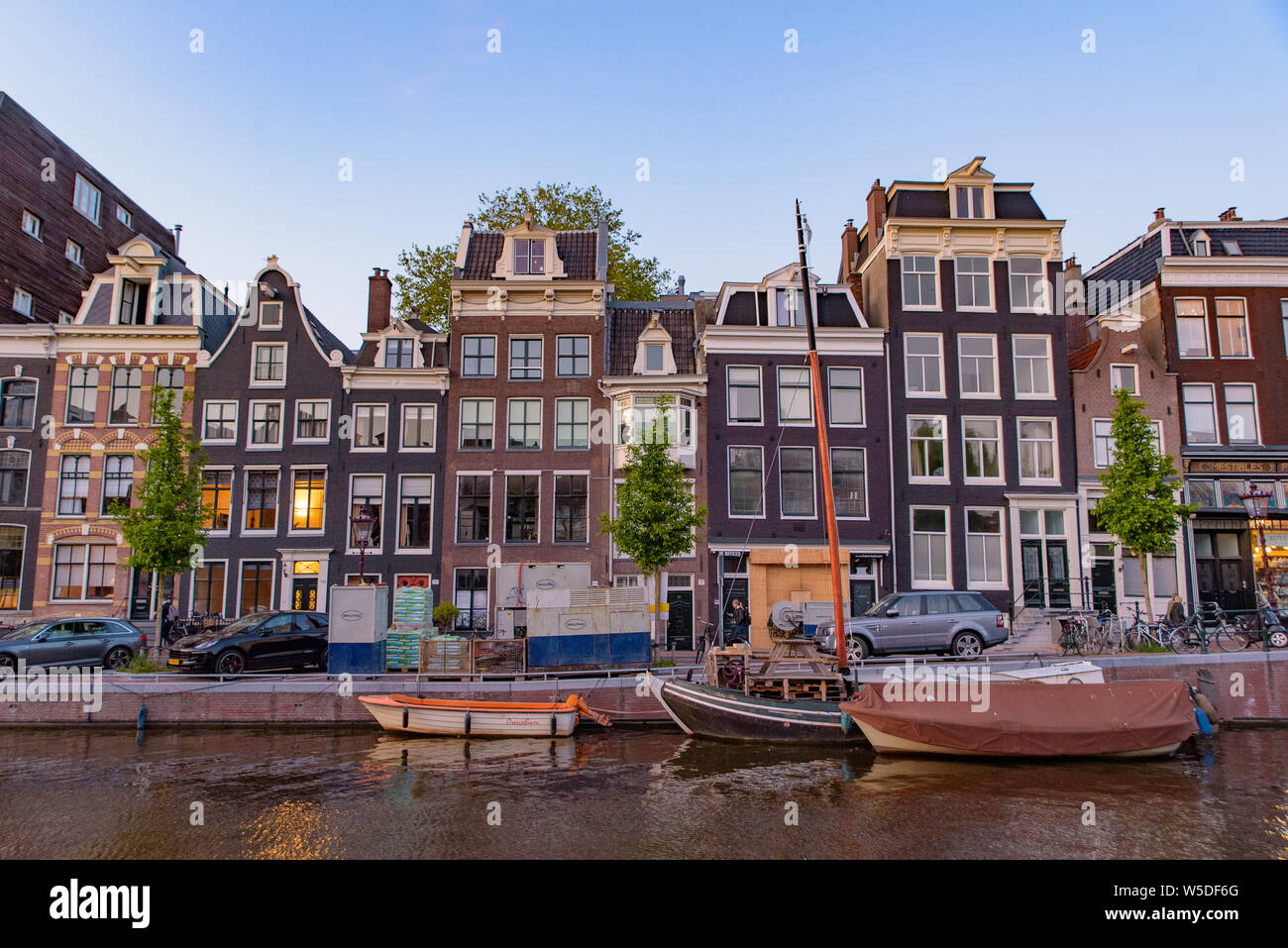 Bâtiments, arbres, et bateaux le long du canal à Amsterdam, Pays-Bas Banque D'Images