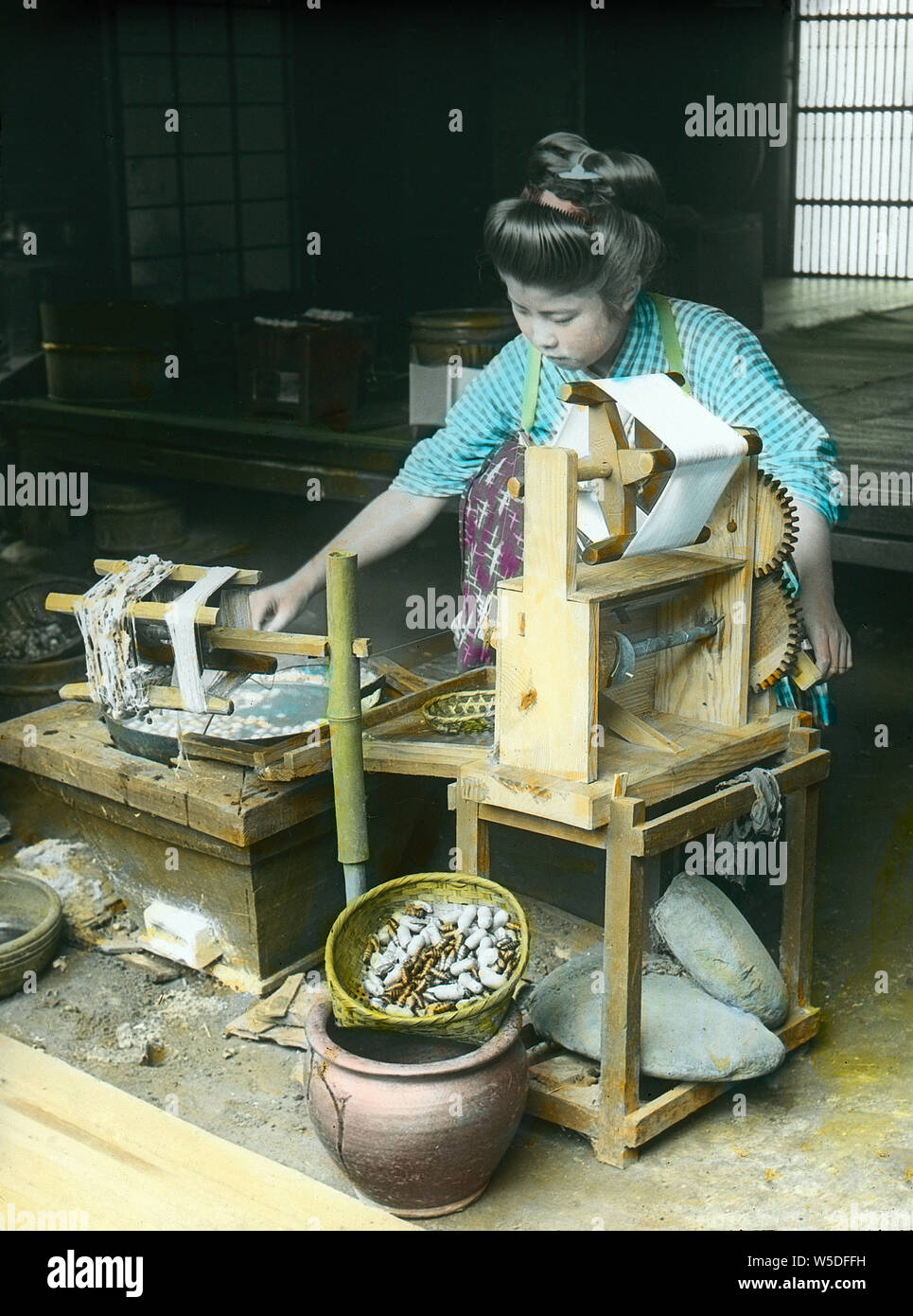 [ 1900 - Japon Japanese Woman Spinning Silk ] - une jeune japonaise est en train de tourner à la maison du 20e siècle soie vintage lame de verre. Banque D'Images