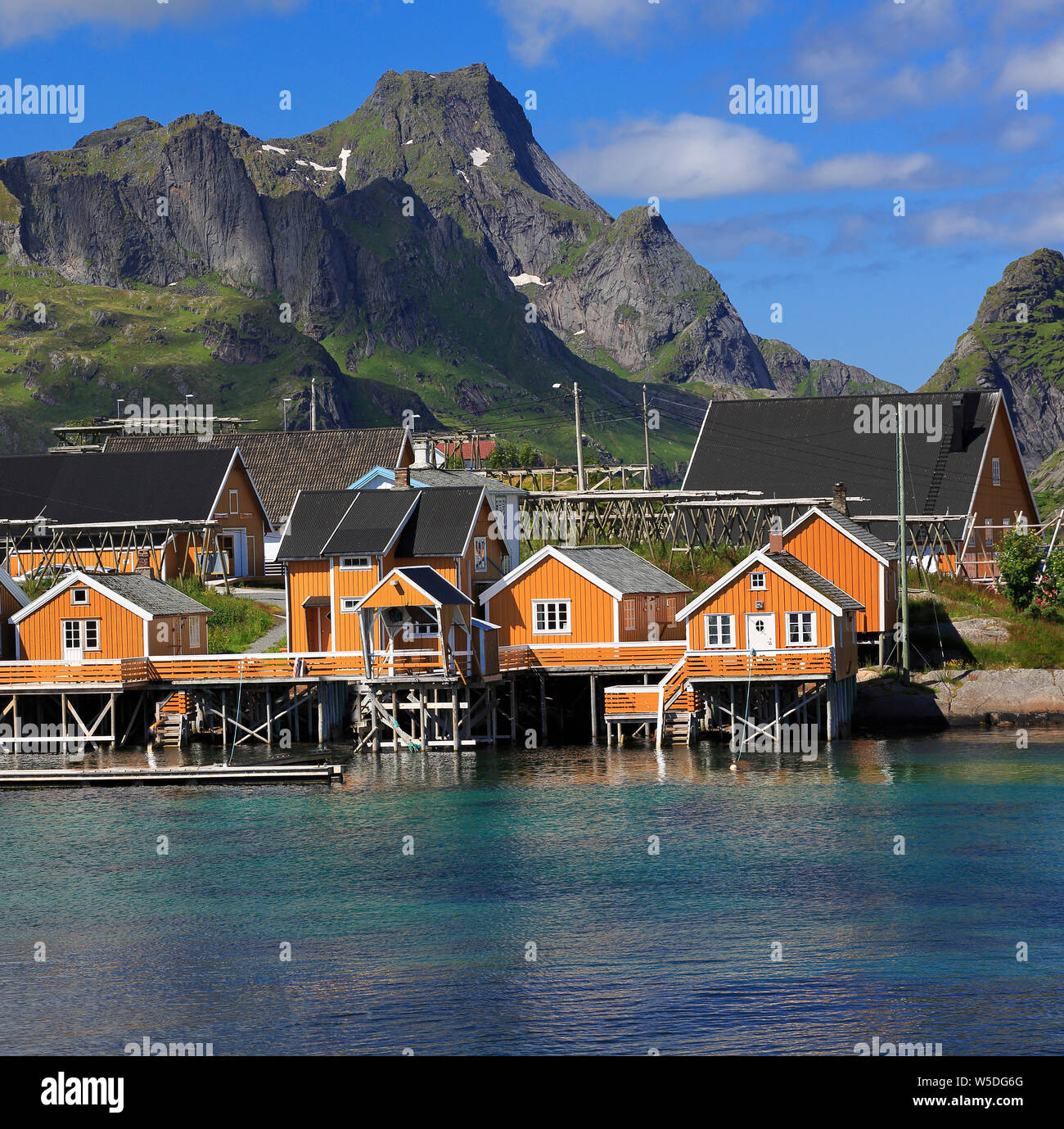 Couleur jaune traditionnelles maisons de la pêche norvégienne dans Sakrisøy, Reine de l'Île, Îles Lofoten, dans le nord de la Norvège Banque D'Images