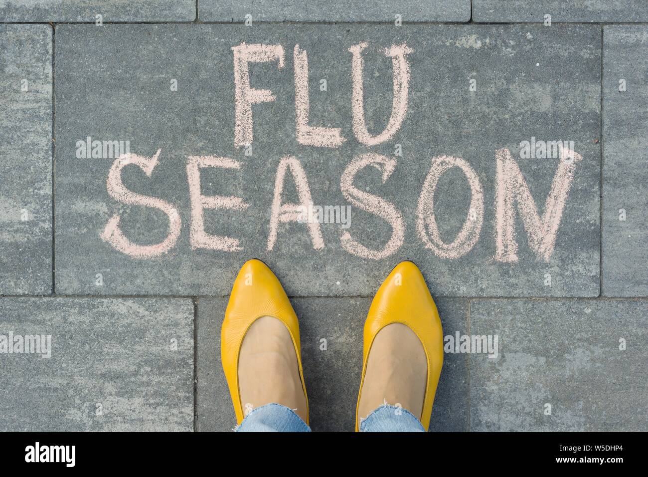 Les pieds avec du texte écrit, la saison de la grippe sur le trottoir gris. Banque D'Images