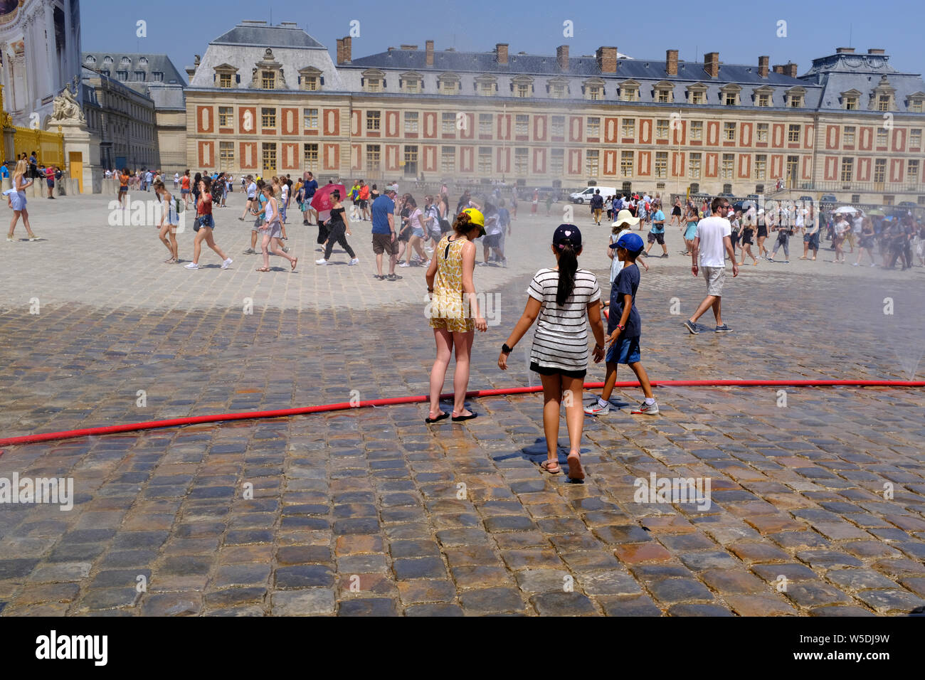 Les gens de se rafraîchir dans l'avant du Palais de Versailles à Paris, France sur une journée très chaude Banque D'Images