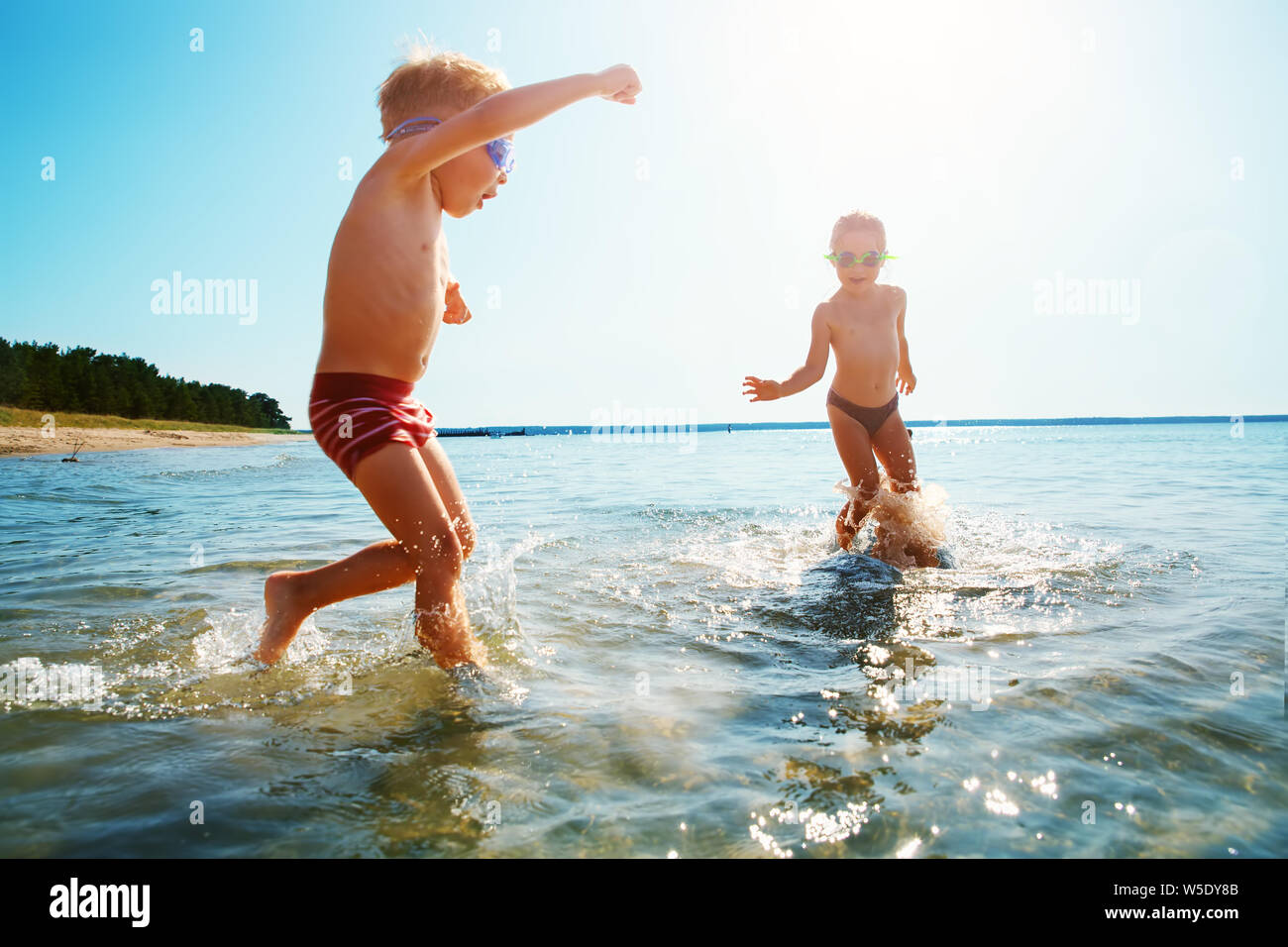 Boy and girl playing on the beach Banque D'Images