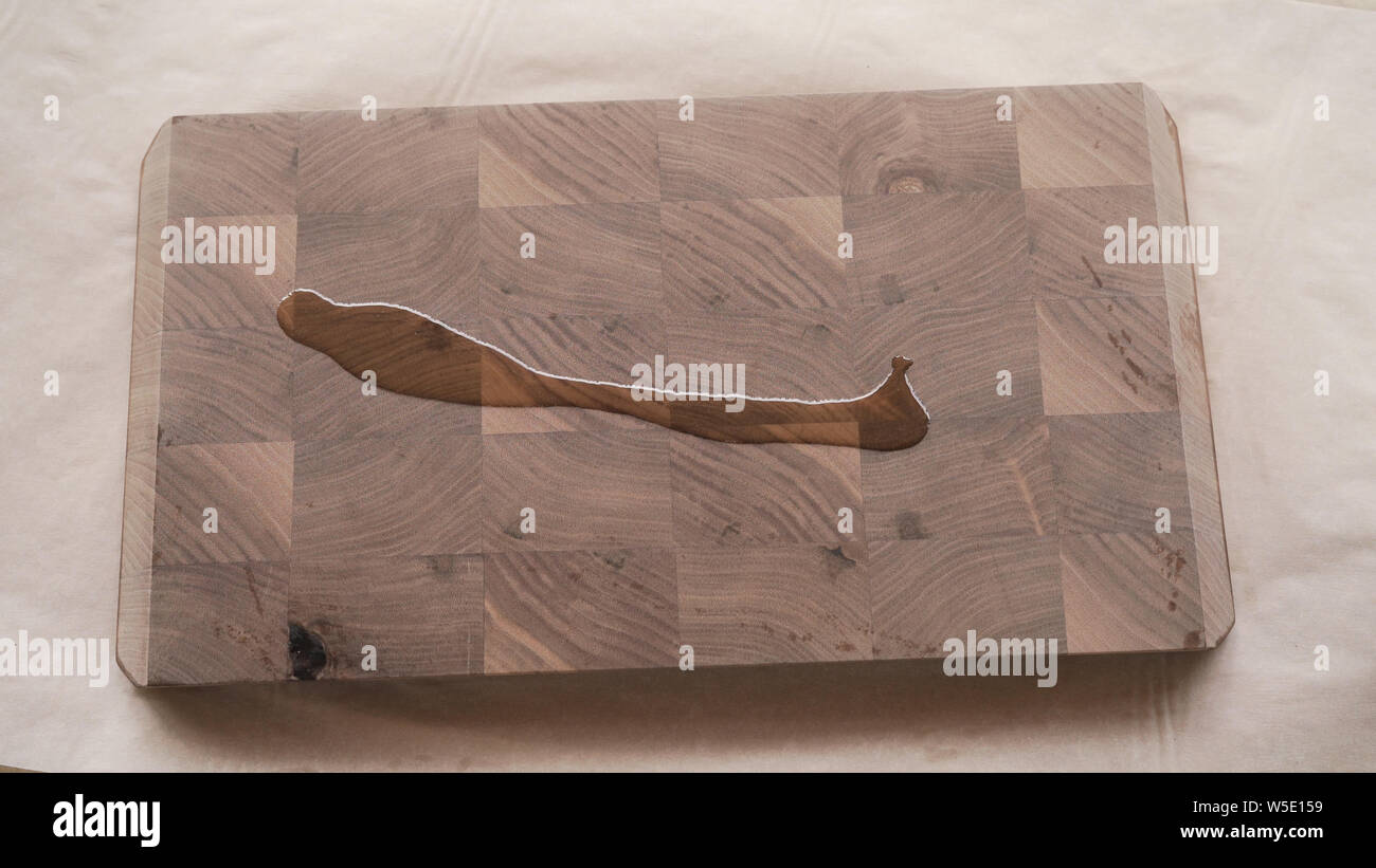 Menuisier d'appliquer de l'huile de finition bois noyer au-dessus de conseil Banque D'Images