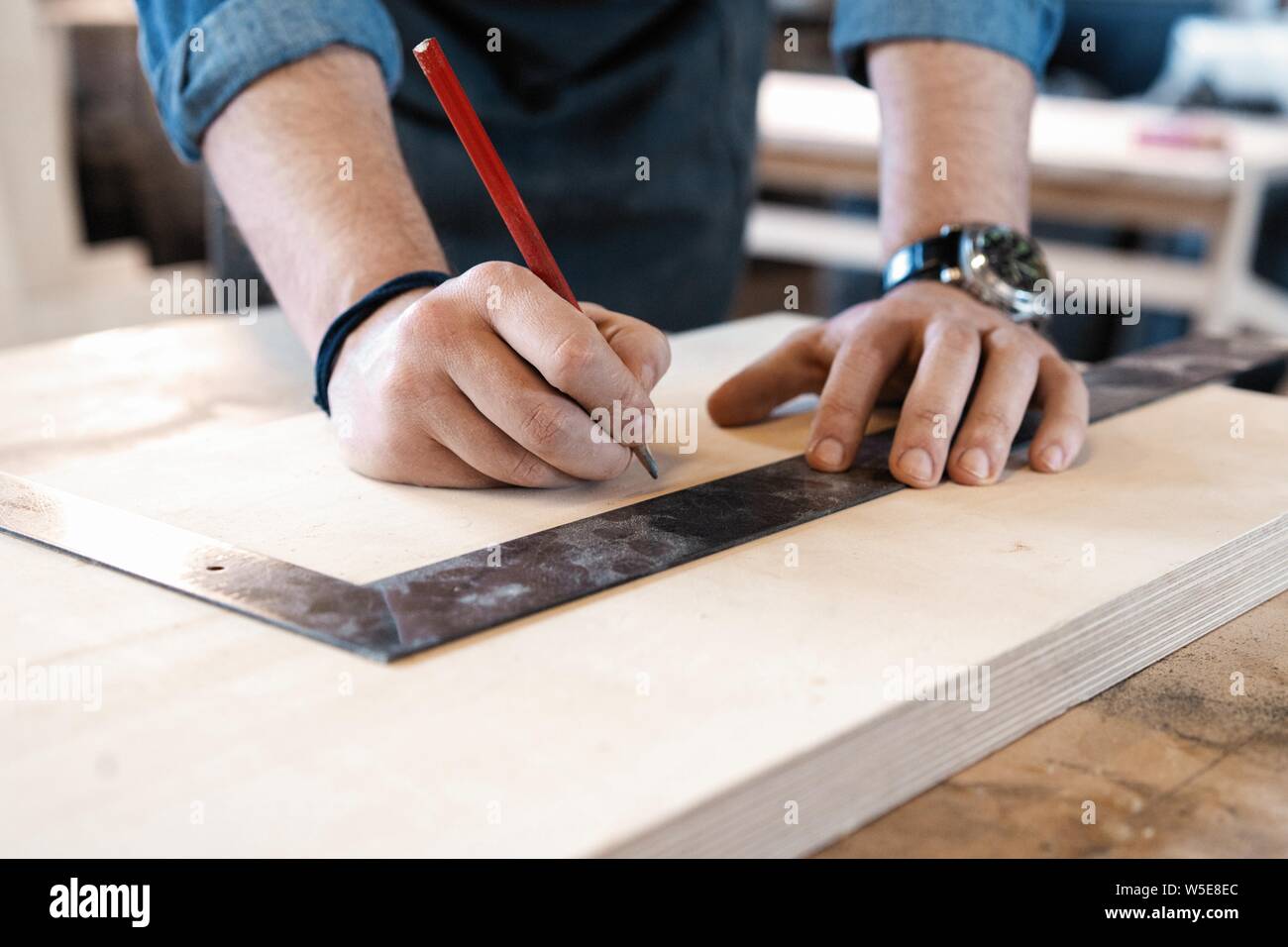 Menuisier travaillant sur machines à bois en atelier de menuiserie. Un homme travaille dans un atelier de menuiserie. Banque D'Images