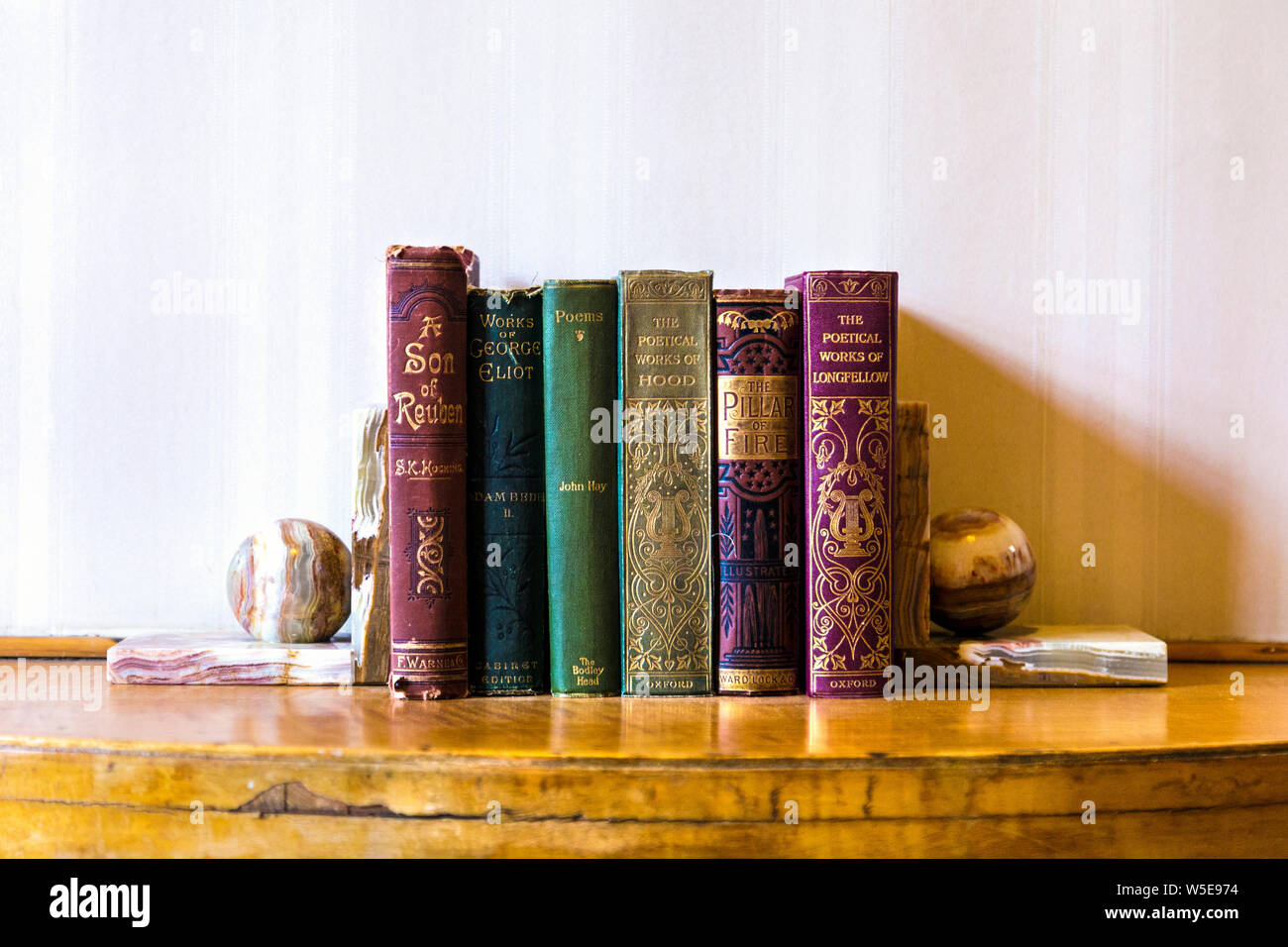 Vieux livres à couverture rigide avec impression feuille d'or sur les épines, Eltham Palace, Yvoir, UK Banque D'Images
