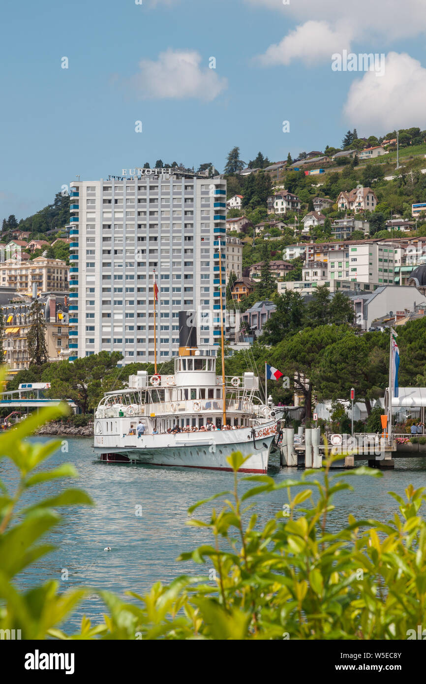 Belle Epoque vintage restauré pédalo nommé Italie amarré au quai de Montreux, lac Léman, Vaud, Suisse avec Eurotel building Banque D'Images