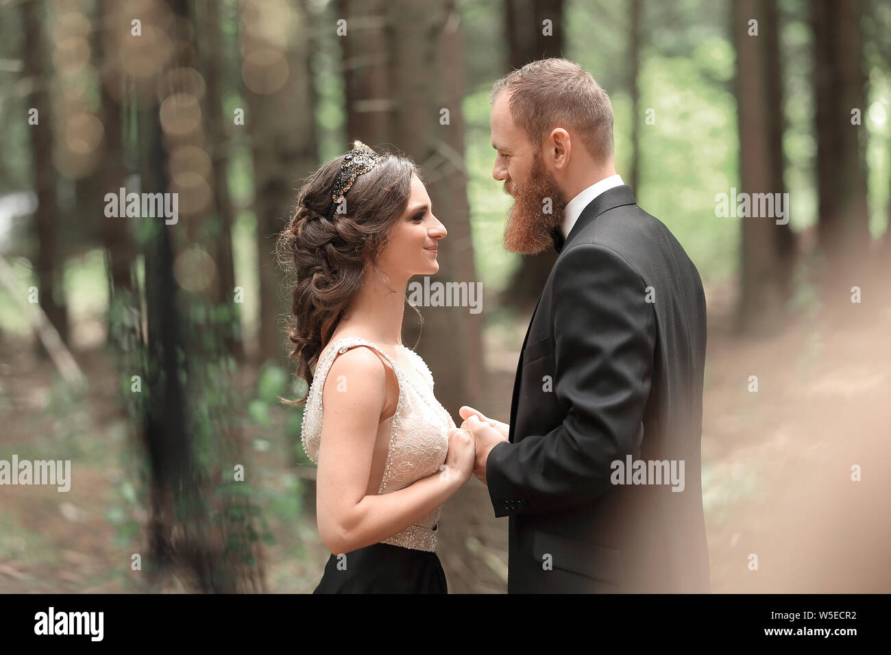 Beau couple amoureux sur le fond d'arbres dans la forêt Banque D'Images