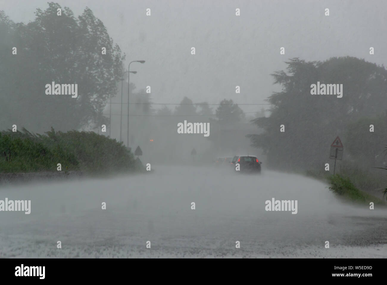 La forte tempête de forte pluie sur la route avec une faible visibilité des voitures. La notion de danger de conduire par mauvais temps Banque D'Images