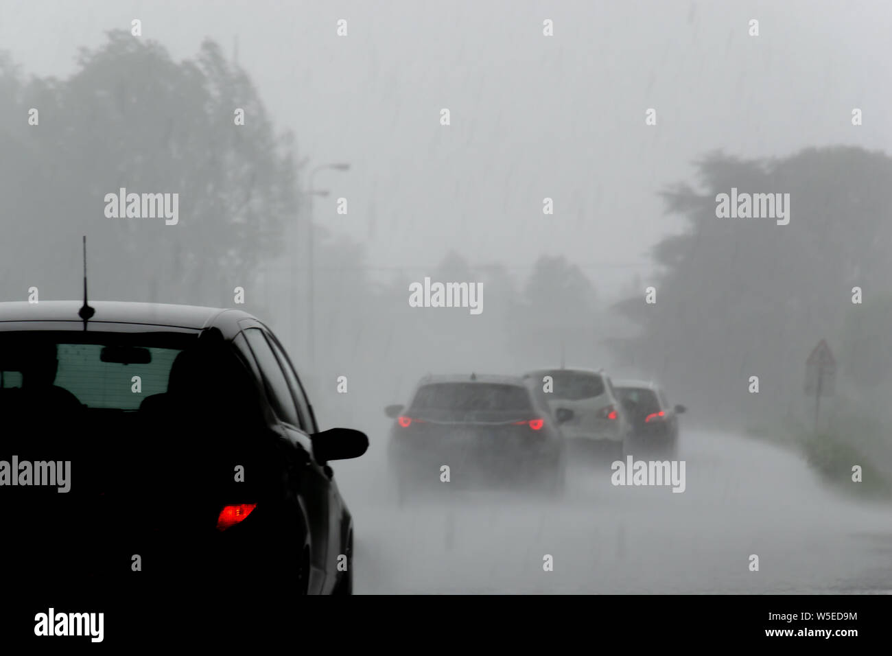 La forte tempête de forte pluie sur la route avec une faible visibilité des voitures. La notion de danger de conduire par mauvais temps Banque D'Images