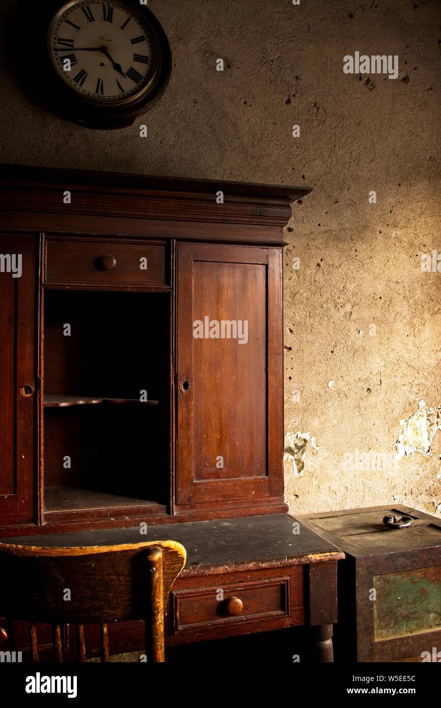 Lumière naturelle, photographie de l'intérieur d'un bureau, chaise, et de l'horloge comme trouvés dans les années 1860, la ville de la flèche de Virginia City, Montana. Banque D'Images