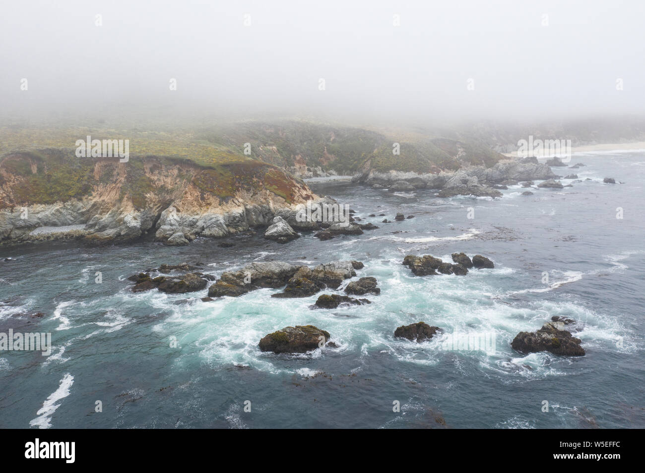 Vu d'une vue à vol d'oiseau, l'océan Pacifique contre les lavages et pittoresques de la côte rocheuse au sud de Monterey en Californie du Nord. Banque D'Images