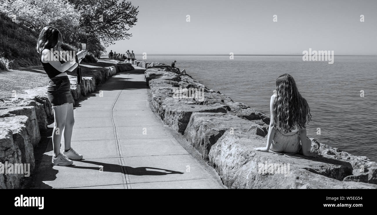 Sur la piste à l'Ontario Lac à Niagara on the Lake, deux jeunes femmes. On prend photo de l'autre. Banque D'Images