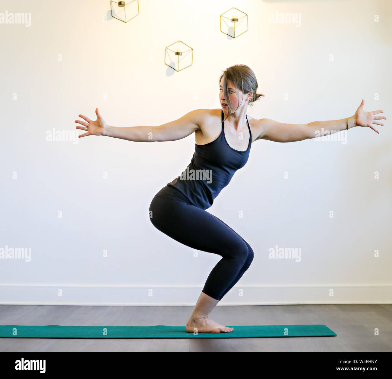 Une jeune brunette woman doing yoga pose sur un fond blanc. Banque D'Images