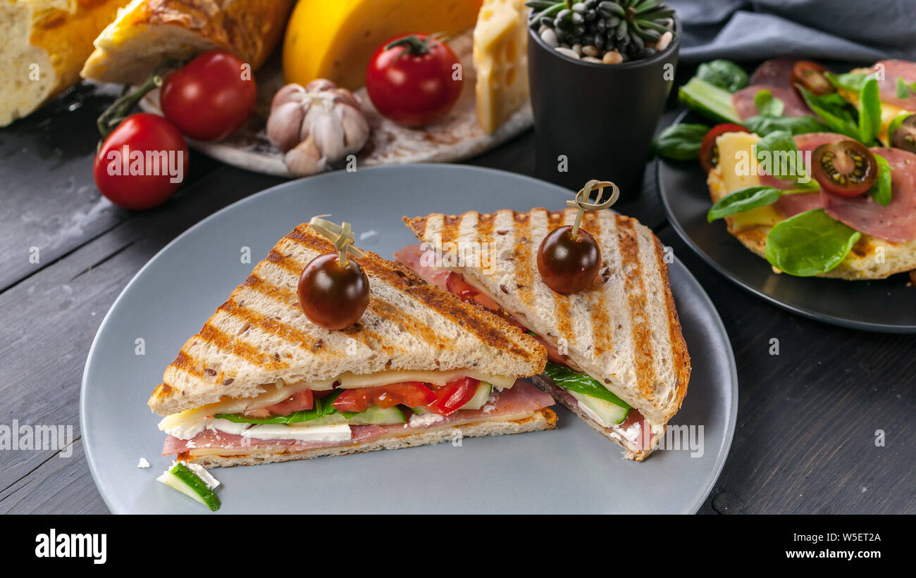 Bannière alimentaire. Toasts de boeuf fumé, tomates, épinards et fromage blanc. Close-up. Plan horizontal Banque D'Images
