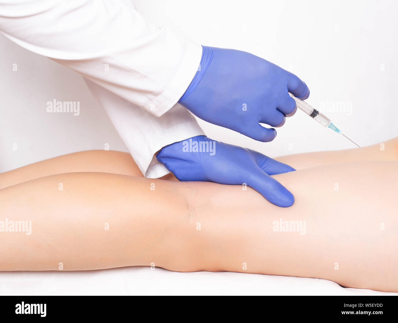 Cosmetologist médecin rend l'injection de beauté à l'arrière des pieds pour lisser les rides. Botox dans les muscles des jambes Banque D'Images