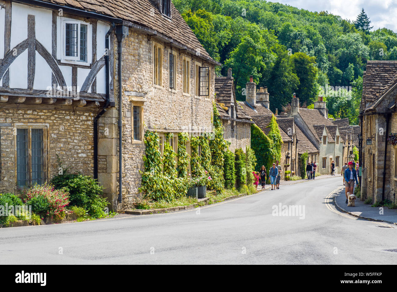 La rue, Castle Combe, dans le Wiltshire avec les visiteurs à explorer Banque D'Images