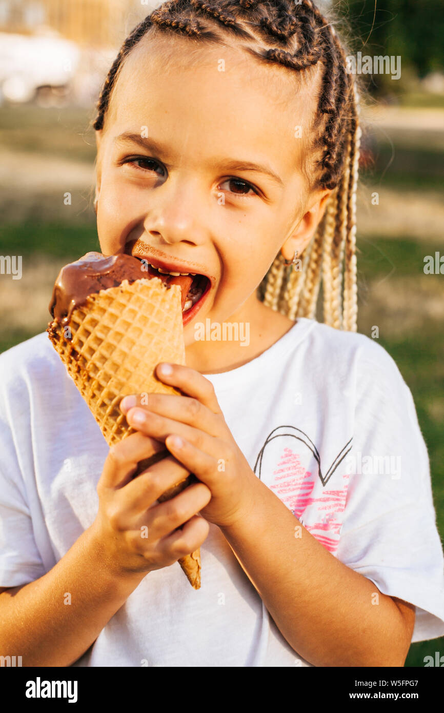 Cute young girl eating a big ice cream Banque D'Images