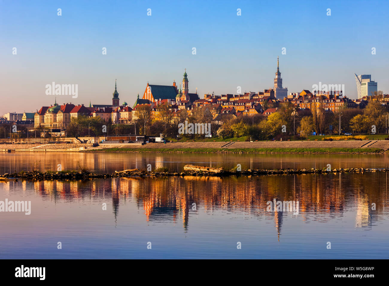 Lever du Soleil vue sur la rivière de la capitale de la Pologne avec l'horizon de la vieille ville et de réflexion dans l'eau. Banque D'Images