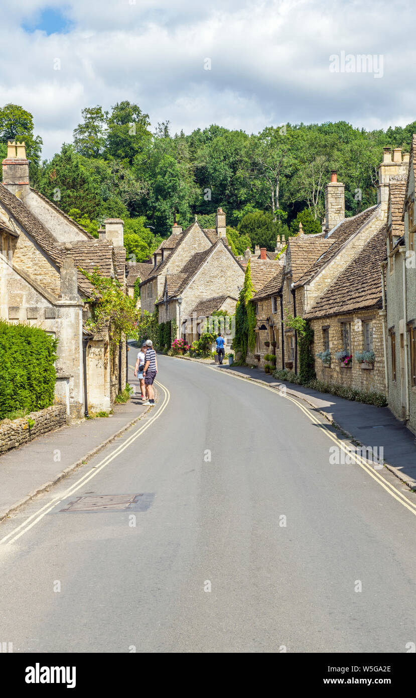 La rue à Castle Combe, Wiltshire, avec les visiteurs appréciant les jolies maisons en pierre Banque D'Images