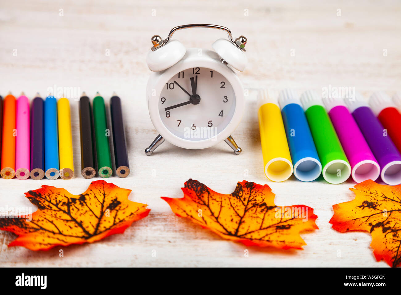 Retour à l'école. Marqueurs, Crayons, réveil et les feuilles d'automne. Banque D'Images
