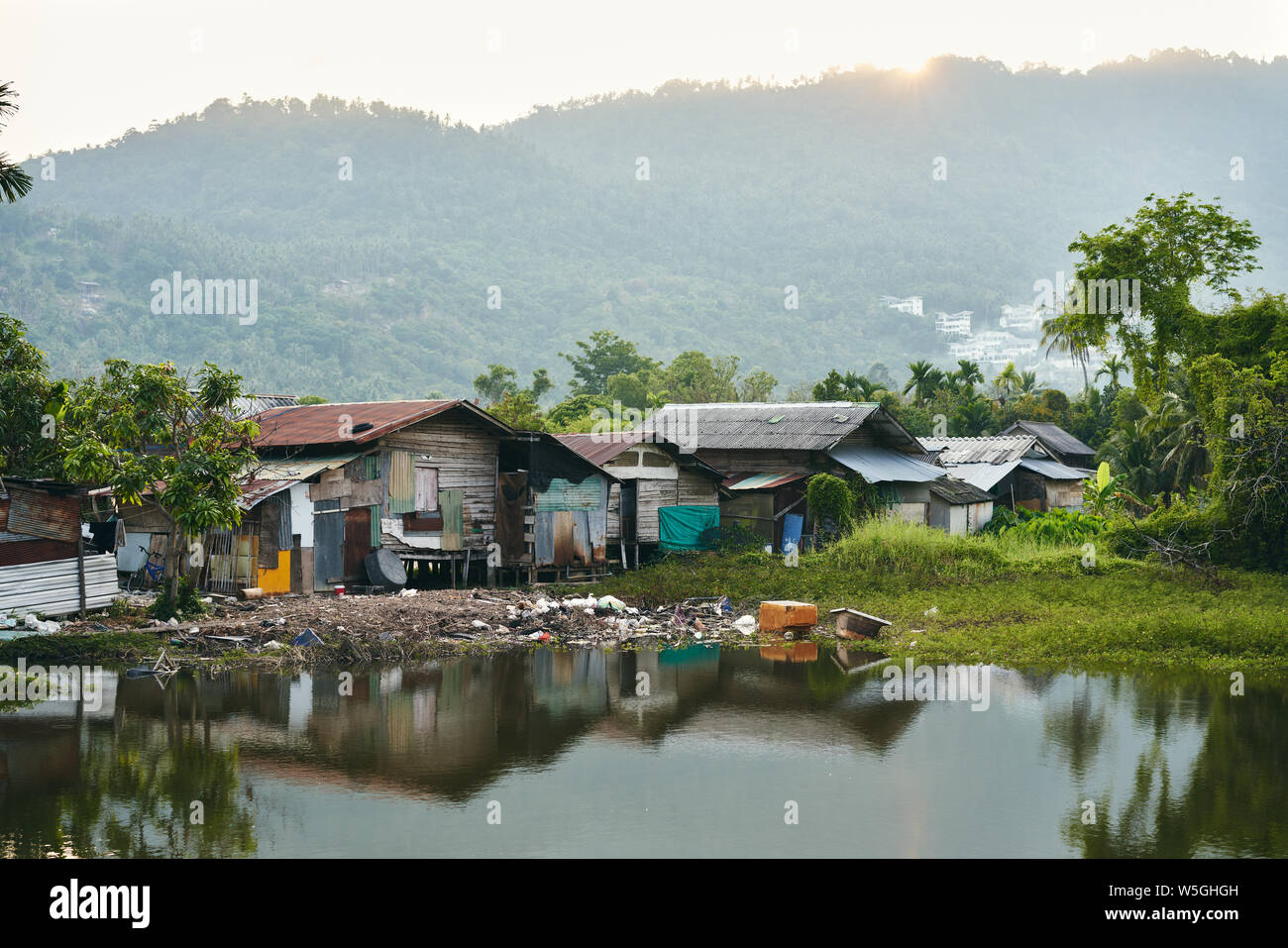 Maisons de taudis sur la rivière pleine de boue et d'ordures en Thaïlande Banque D'Images