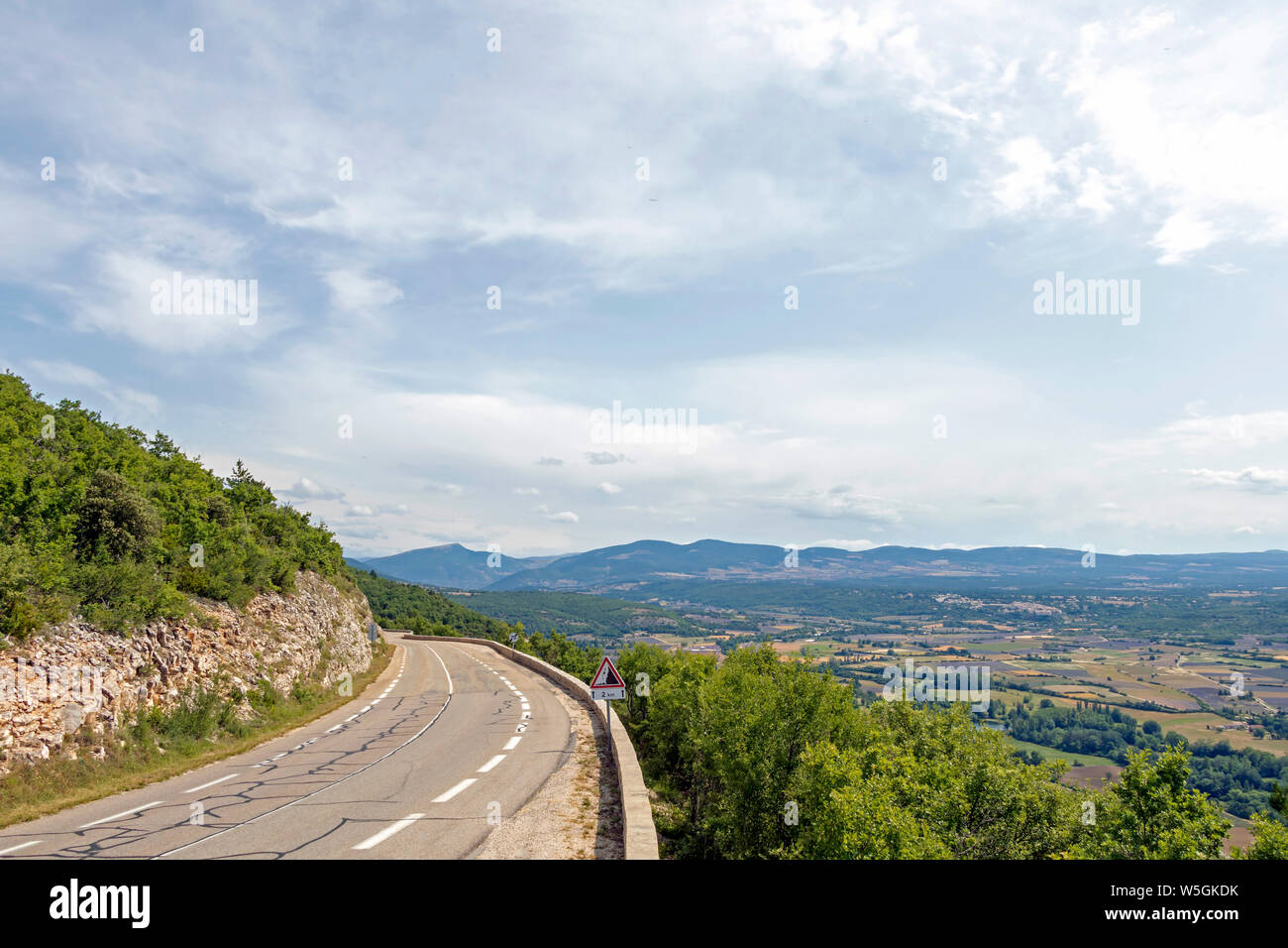 Route asphaltée courbe dans les montagnes françaises avec pic de montagne et forêt verte dans la distance. Road Trip vocation dans la Provence, France, Europe du Sud Banque D'Images