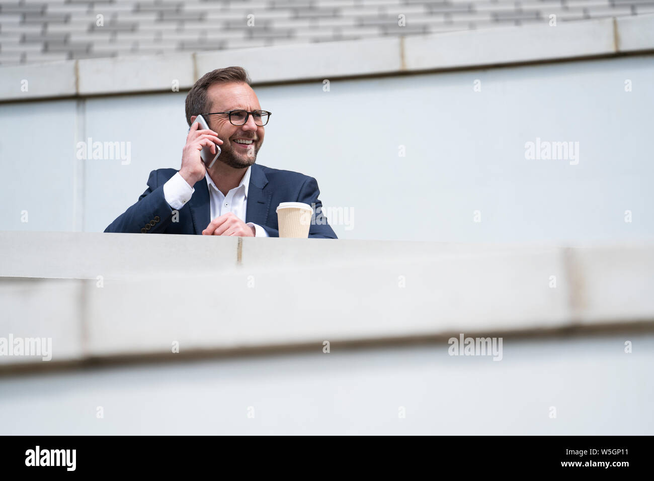Mature Businessman Prendre appel sur téléphone mobile à l'extérieur permanent Office Building Banque D'Images