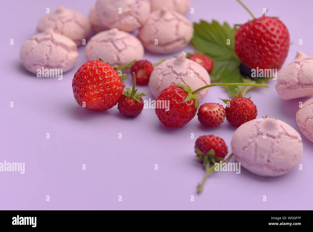 Peu de meringues aux fraises sur fond de couleur Banque D'Images