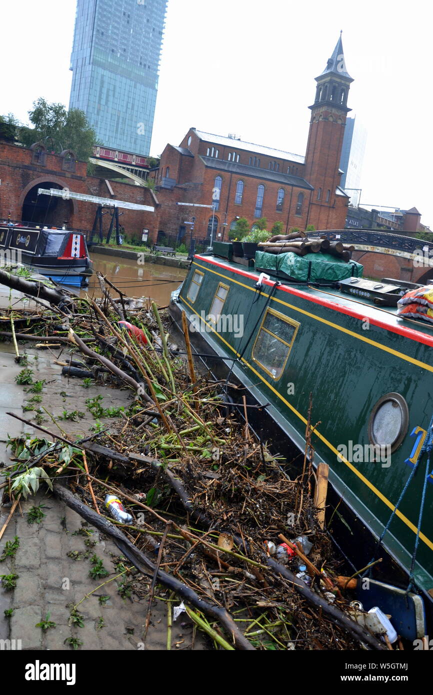 Les débris laissés à côté d'un bateau après le canal à Castlefield, Manchester, UK, a inondé le 28 juillet 2019. De fortes pluies dans le Nord-Ouest a mené à la Met Office émettre plusieurs avertissements d'inondations dans la région. Banque D'Images